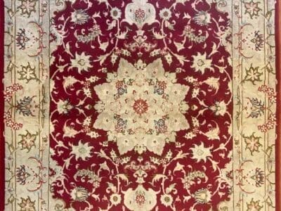 Tappeto Tabriz decorato rosso e beige con disegno floreale simmetrico e bordo decorativo.