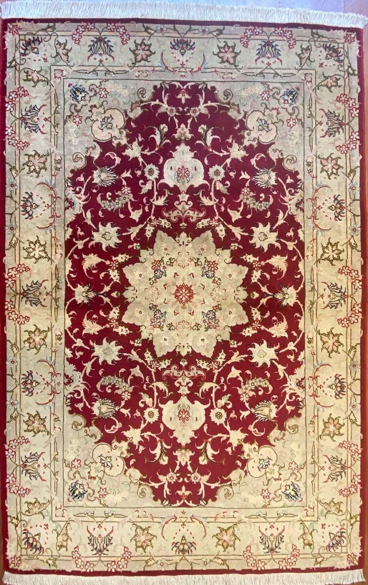 Tappeto Tabriz decorato rosso e beige con disegno floreale simmetrico e bordo decorativo.