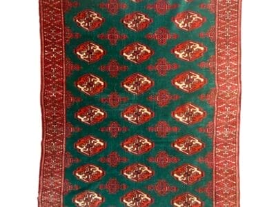 Un tappeto persiano con disegni rossi e verdi.