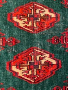 Un tappeto persiano con vivaci disegni rossi e verdi.