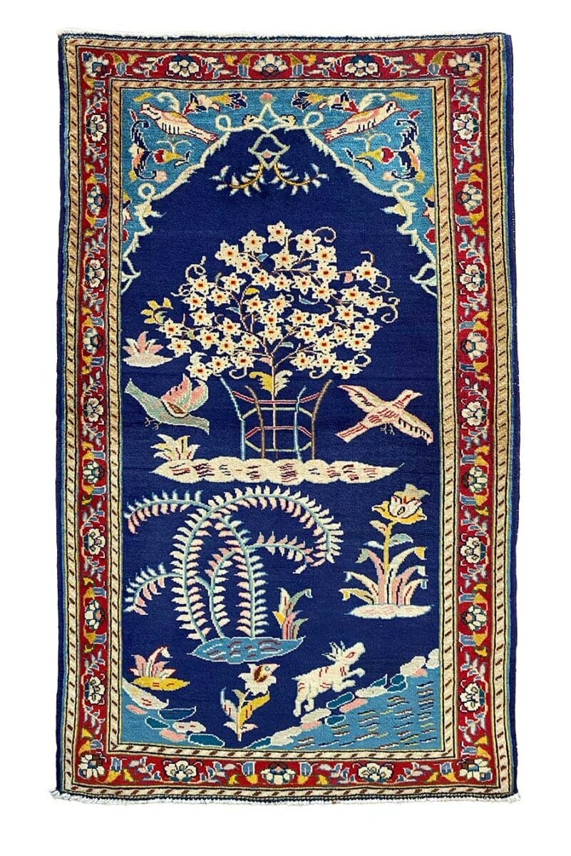 Un tappeto blu con uccelli e fiori sopra.