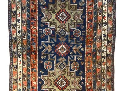 Un tappeto geometrico blu e arancione, ispirato al design di Shirvan Lesghi.