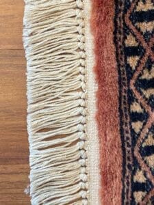 Un primo piano di un tappeto Tappeto Pakistano con le frange.