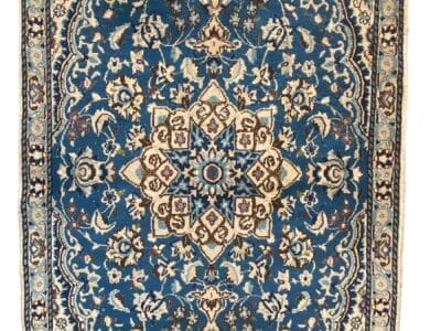 Un tappeto Nain blu e beige dal design ornato.