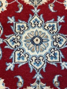 Un tappeto Nain rosso e blu dal design ornato.