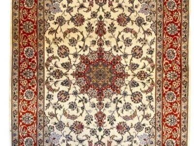 Tappeto tradizionale Isfahan Seta con intricati motivi floreali e un medaglione centrale, incorniciato da bordi decorati.
