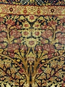 Una vista ravvicinata di un motivo floreale dettagliato su un tappeto in tessuto Tappeto Kirman.