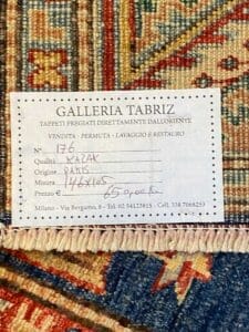 Primo piano di un'etichetta di certificato su un tappeto Tabriz che ne indica la qualità, l'origine e le dimensioni con le parole chiave SEO di Bozza automatica.