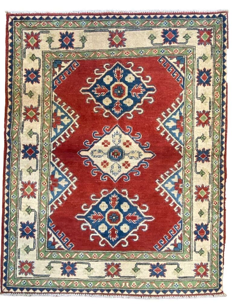Tappeto tradizionale tessuto a mano con intricati motivi geometrici e floreali nei toni del rosso, blu e beige, che mostra la precisione del disegno automatico nel suo design.