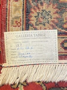 Etichetta su un tappeto persiano che indica i dettagli del negozio e le specifiche del tappeto come origine, dimensioni e qualità. Bozza automatica.