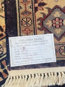 Etichetta della Galleria Tabriz contenente informazioni su un tappeto persiano, con indicazione della provenienza, delle dimensioni e del prezzo, posta sul tappeto stesso come "Bozza automatica".