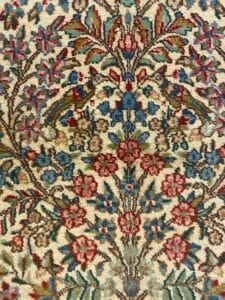 Una vista ravvicinata di un tappeto dettagliato, automatico, con motivi floreali in una varietà di colori.