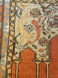 Primo piano di un tappeto tradizionale decorato con motivi intricati e una varietà di colori, ideale per migliorare il contenuto visivo dei sistemi di gestione dei documenti.
