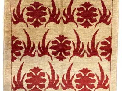 Tappeto Gazni realizzato artigianalmente con motivi floreali rossi su fondo beige.