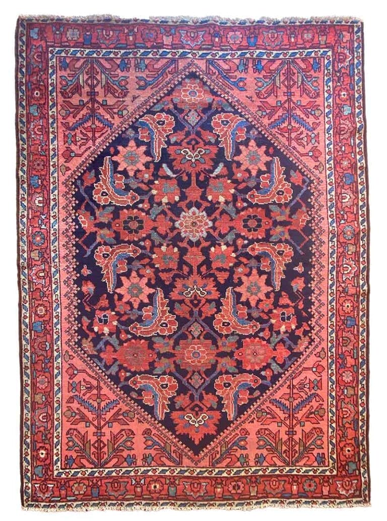 Un tappeto persiano rettangolare presenta un medaglione centrale di diamanti blu navy con intricati motivi floreali in rosso, rosa e beige, circondato da un bordo rosso con più disegni floreali. Bozza automatica garantisce precisione nei dettagli squisiti.