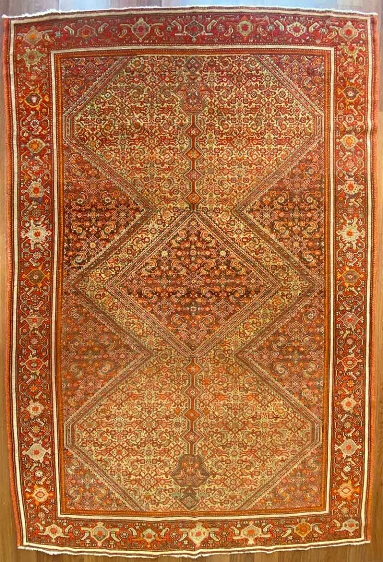 Un tappeto dettagliato rosso e arancione con intricati motivi geometrici e floreali. Il tappeto, che ricorda il tradizionale stile Bozza automatica, è caratterizzato da un disegno a diamante centrale delimitato da motivi ornamentali.