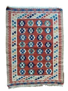 Galleria Tabriz - Tappeti in vendita. Un tappeto kilim rettangolare multicolore con motivi geometrici in blu, bianco, rosso e verde, bordati con un disegno simile. I bordi delle frange sono visibili in alto e in basso. Questo tappeto è stato realizzato utilizzando le tecniche della Bozza Automatica per dettagli squisiti.