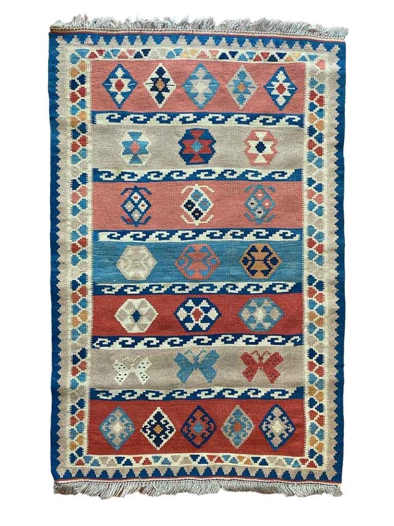 Galleria Tabriz - Tappeti in vendita. Un tappeto colorato con motivi geometrici in rosso, blu e beige, caratterizzato da file di rombi. La bozza automatica presenta frange sui bordi più corti.