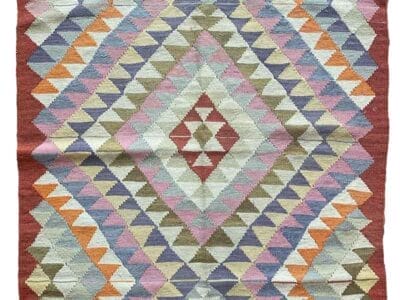 Galleria Tabriz - Tappeti in vendita. Il tappeto a motivi geometrici di Bozza presenta un sorprendente mix di colori pastello e audaci, tra cui rosso, arancione, viola, blu e verde, tutti disposti a forma di diamante per un design accattivante.