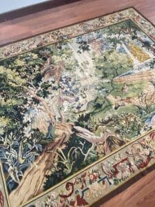 Galleria Tabriz - Tappeti in vendita. Un arazzo dettagliato, che ricorda un disegno di Bozza automatica, raffigura una rigogliosa scena di foresta con alberi, fogliame e animali disposti con grazia su un pavimento di legno.