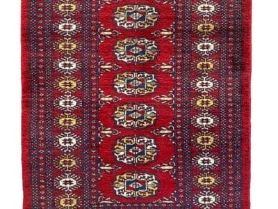 Galleria Tabriz - Tappeti in vendita. Un tappeto rosso con intricati disegni geometrici e motivi ripetuti, impreziosito da toni blu navy, bianco e oro, che creano un effetto di armonia visiva.