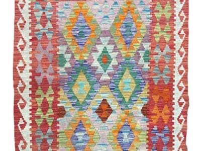 Galleria Tabriz - Tappeti in vendita. Un tappeto intrecciato colorato con motivi geometrici a forma di diamante e frange lungo i bordi superiore e inferiore, che aggiunge un tocco di stile bozza automatica a qualsiasi stanza.