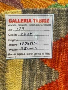 Galleria Tabriz - Tappeti in vendita. Un'etichetta tessile della Galleria Tabriz, creata con Bozza automatica, elenca i dettagli: N. 229, Qualità: Kilim, Origine non specificata, Dimensioni: 175x125, Prezzo: 380,00€. Le informazioni di contatto sono incluse in basso.