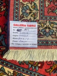 Galleria Tabriz - Tappeti in vendita. Primo piano di un angolo di un tappeto persiano, l'etichetta mostra 