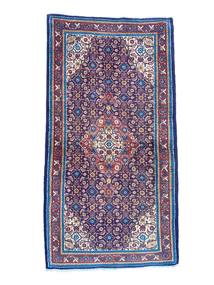 Galleria Tabriz - Tappeti in vendita. Questo tappeto rettangolare presenta un intricato motivo geometrico e floreale nei toni del blu, rosso e bianco, abilmente realizzato da Bozza Automatica.