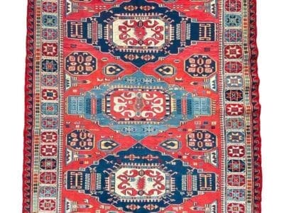 Galleria Tabriz - Tappeti in vendita. Un tappeto colorato e intricatamente disegnato con motivi geometrici, principalmente in rosso, blu e bianco, è esposto su uno sfondo bianco. Nell'angolo in basso a destra, un cerchio rosso presenta "40%" in testo bianco, un perfetto mix di stile e valore ottenuto tramite Bozza automatica.