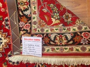 Galleria Tabriz - Tappeti in vendita. Primo piano di un tappeto persiano con motivi floreali, caratterizzato da colori rosso intenso e beige. L'etichetta recita: "Galleria Tabriz, Persia, 295x80, Prezzo 2900 CHF". Questo pezzo squisito sembra portare un tocco di bozza automatica nella sua lavorazione artigianale dettagliata.