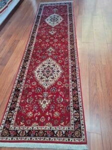 Galleria Tabriz - Tappeti in vendita. Un tappeto rosso in stile persiano con intricati motivi floreali e medaglioni, che ricorda un capolavoro di Bozza, impreziosisce con eleganza il pavimento in legno.