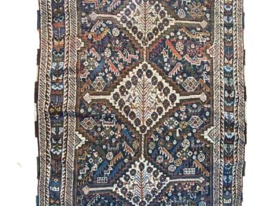 Galleria Tabriz - Tappeti in vendita. Intricato tappeto Gashgai blu e rosso con motivi geometrici, esposto su uno sfondo bianco. Un cerchio rosso nell'angolo in alto a destra mostra un "40%" bianco.