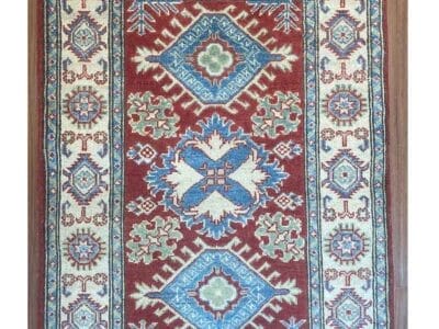 Galleria Tabriz - Tappeti in vendita. Un tappeto tradizionale con motivi rossi, blu e crema mette in mostra intricati disegni geometrici. Nell'angolo in alto a destra, un cerchio rosso mostra "60%" in grassetto bianco, una bozza automatica di stile ed eleganza.