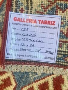 Galleria Tabriz - Tappeti in vendita. Un cartellino del prezzo su un tappeto a fantasia della Galleria Tabriz fornisce dettagli come origine (Afghanistan), qualità (Ghazni) e dimensioni (120x84 cm). Utilizzando una bozza automatica, il prezzo di vendita è scontato a 200€.