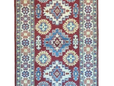 Galleria Tabriz - Tappeti in vendita. Un tappeto a motivi rossi con disegni geometrici blu e bianchi è elegantemente drappeggiato sul pavimento, emanando un fascino bozza automatica. Nell'angolo in alto a destra, un cerchio rosso in grassetto mostra un allettante sconto del "60%".
