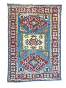 Galleria Tabriz - Tappeti in vendita. Tappeto rettangolare ornato con intricati motivi geometrici in ricchi rossi, blu e crema. Questo pezzo vanta disegni simmetrici incorniciati da un bordo decorato con delicati accenti floreali, perfetto per aggiungere un tocco elegante a qualsiasi stanza.