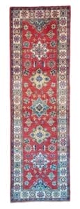 Galleria Tabriz - Tappeti in vendita. Un tappeto rosso rettangolare con intricati motivi geometrici e motivi floreali multicolori, bordato da una serie di piccoli disegni decorativi, conferisce automaticamente un tocco di stile a qualsiasi spazio.