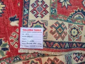 Galleria Tabriz - Tappeti in vendita. Primo piano di un tappeto decorato con un'etichetta recante la scritta "Galleria Tabriz", che riporta il numero dell'articolo, la qualità, l'origine, le dimensioni e il prezzo in euro: un vero capolavoro impreziosito dalla tecnica della bozza automatica.