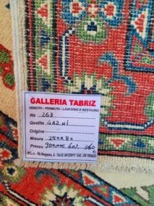 Galleria Tabriz - Tappeti in vendita. Primo piano di un tappeto colorato con etichetta della "Galleria Tabriz". L'etichetta riporta dimensioni, prezzo e qualità in italiano.