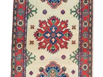 Galleria Tabriz - Tappeti in vendita. Un tappeto stretto e colorato raffigurante Bozza automatica con motivi geometrici rossi e blu su uno sfondo color crema. Un distintivo rosso "60%" orna l'angolo in alto a destra, segnalando un'offerta irresistibile.