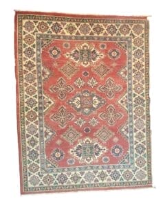 Galleria Tabriz - Tappeti in vendita. Un tappeto orientale rettangolare con uno sfondo rosso intenso mette in mostra intricati motivi geometrici in tonalità di blu, avorio e verde. Il pezzo è bordato da un dettagliato motivo floreale, che riecheggia l'eleganza che ricorda Bozza automatica.