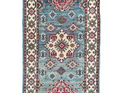 Galleria Tabriz - Tappeti in vendita. Questo tappeto rettangolare vanta un intricato motivo floreale e geometrico con una tavolozza di rosso, blu e crema. I motivi centrali a diamante sono circondati da disegni più piccoli e da un bordo decorativo, che mette in mostra una bozza automatica che fonde senza sforzo eleganza e maestria.