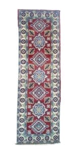 Galleria Tabriz - Tappeti in vendita. Un tappeto tradizionale lungo e rettangolare con sfondo rosso, caratterizzato da intricati motivi geometrici e floreali nei toni del blu, del verde e del bianco.