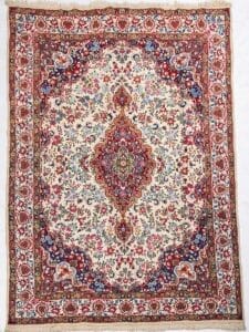 Galleria Tabriz - Tappeti in vendita. Tappeto persiano ornato con intricati motivi floreali nei colori rosso, blu e crema, caratterizzato da un medaglione centrale: un design senza tempo per interni eleganti.