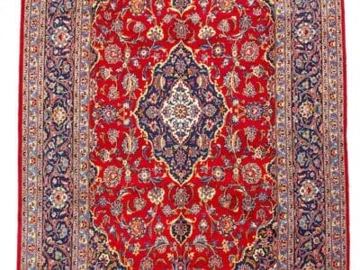 Galleria Tabriz - Tappeti in vendita. Un tappeto persiano con sfondo rosso, medaglione centrale e intricati motivi floreali nei toni del blu, dell'avorio e dell'oro conferisce un'eleganza a qualsiasi spazio.