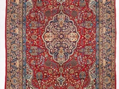 Galleria Tabriz - Tappeti in vendita. Tappeto persiano Qum ornato con intricati motivi floreali nei toni del rosso, del blu, del crema e dell'oro, bordati da disegni dettagliati.