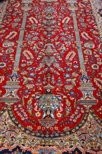 Galleria Tabriz - Tappeti in vendita. Un Tappeto Qum rosso vibrante con intricati motivi floreali e geometrici in blu, oro e crema, che mette in mostra l'arte di Qum Persia.