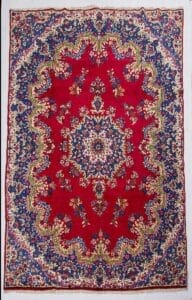Galleria Tabriz - Tappeti in vendita. Tappeto persiano Tappeto Kirman ornato con centro rosso, motivi floreali e bordo blu e crema.