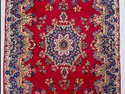Galleria Tabriz - Tappeti in vendita. Tappeto persiano Tappeto Kirman ornato con centro rosso, motivi floreali e bordo blu e crema.